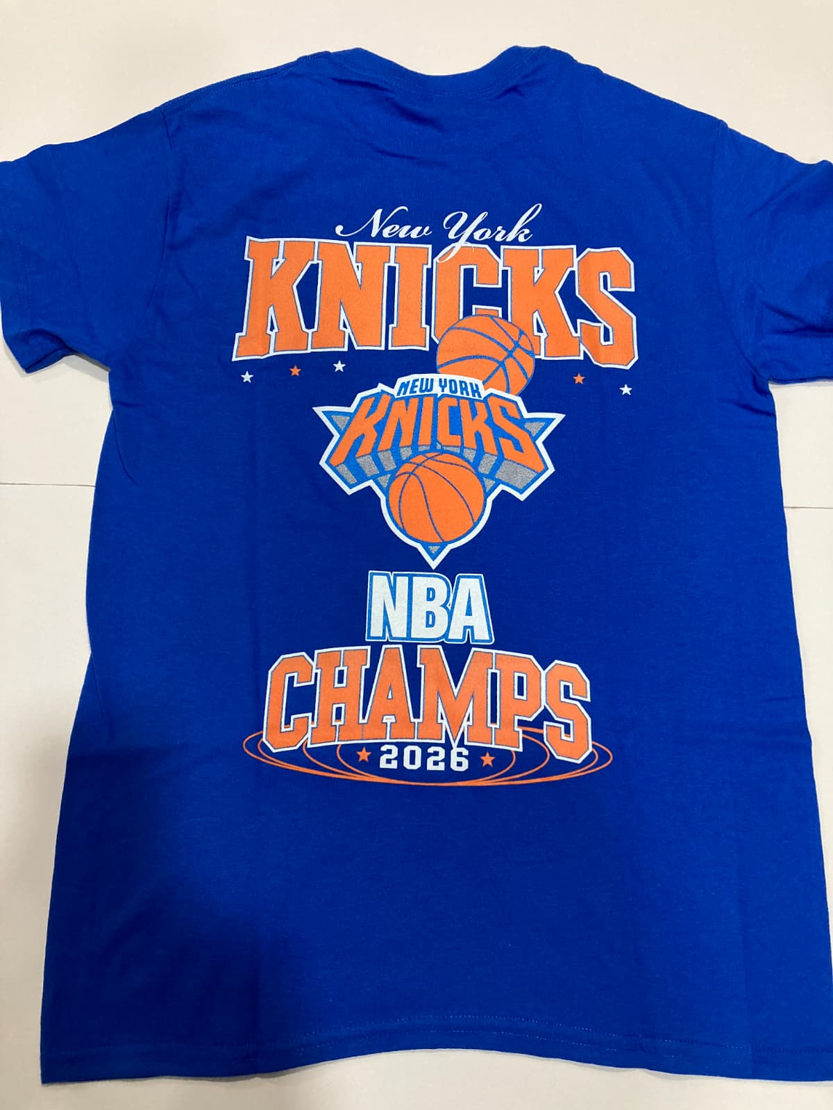 Royal blue t-shirt with New York Knicks NBA Champs 2026 text and logo, back view, round neck t-shirt