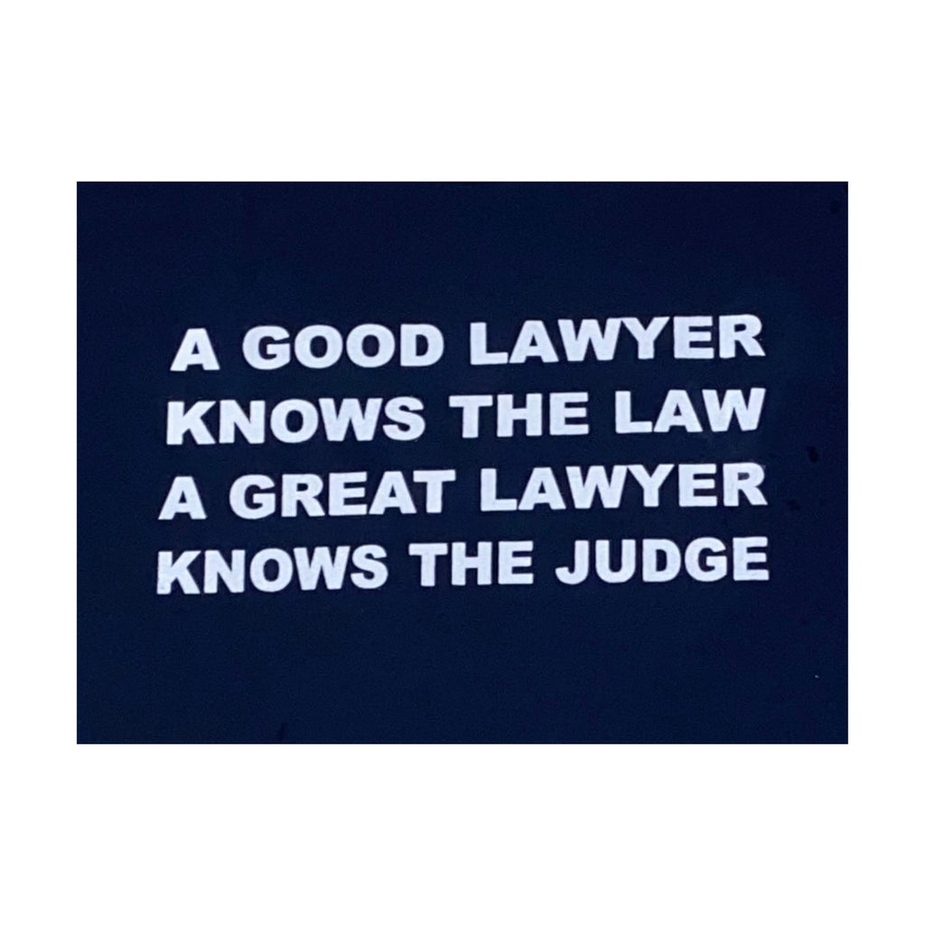 Navy blue sign with lawyer joke on white letters